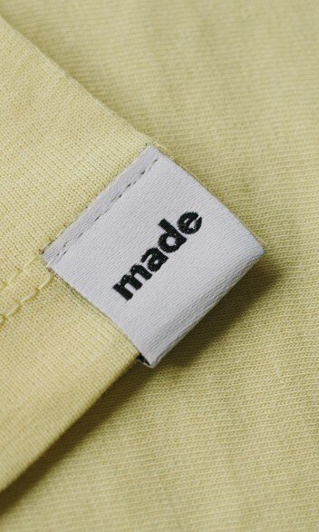 Weißes Weblabel auf gelbem Textil