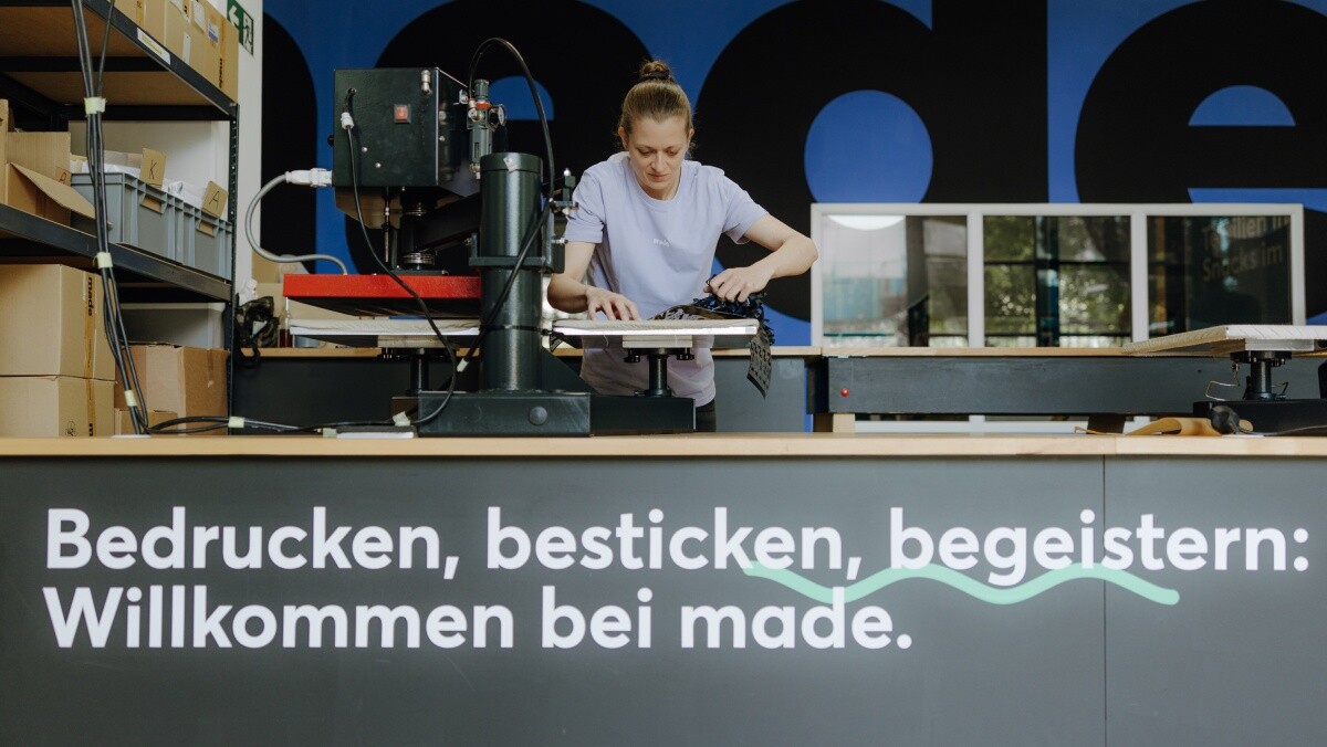 Eine Mitarbeiterin von made for brands beim Bedrucken von Textilien