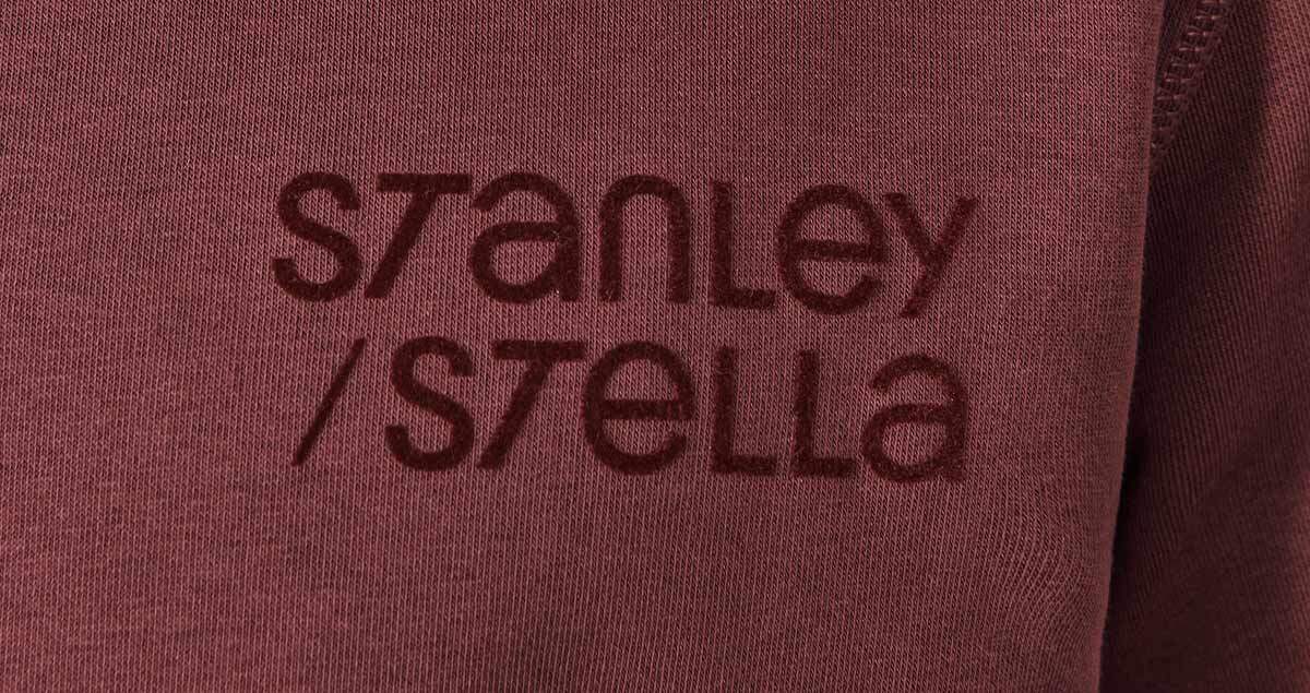 Ein Flockdruck mit dem Logo von Stanley/Stella auf einem dunkelroten Pullover