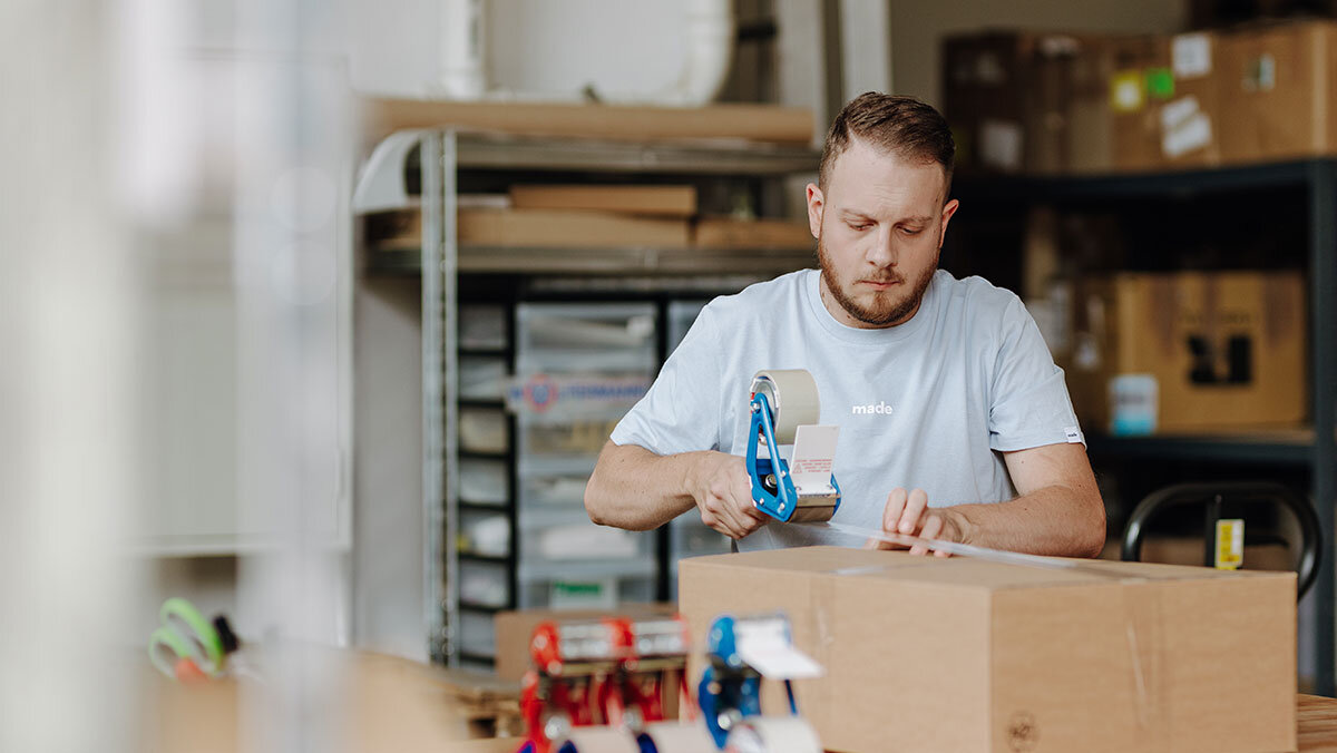 Ein Mitarbeiter macht ein Paket versandfertig